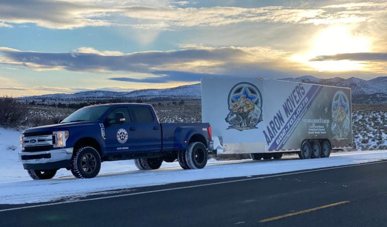 Photo of Aaron Movers truck and trailer in snow covered mountains