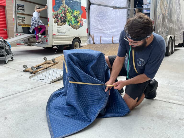 aaron movers wrapping protective blanket around furniture